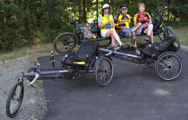 Photo of our pair of Hase Ketttweisels hooked together with Janis, Kathy and Ralph sitting on a bench behind them